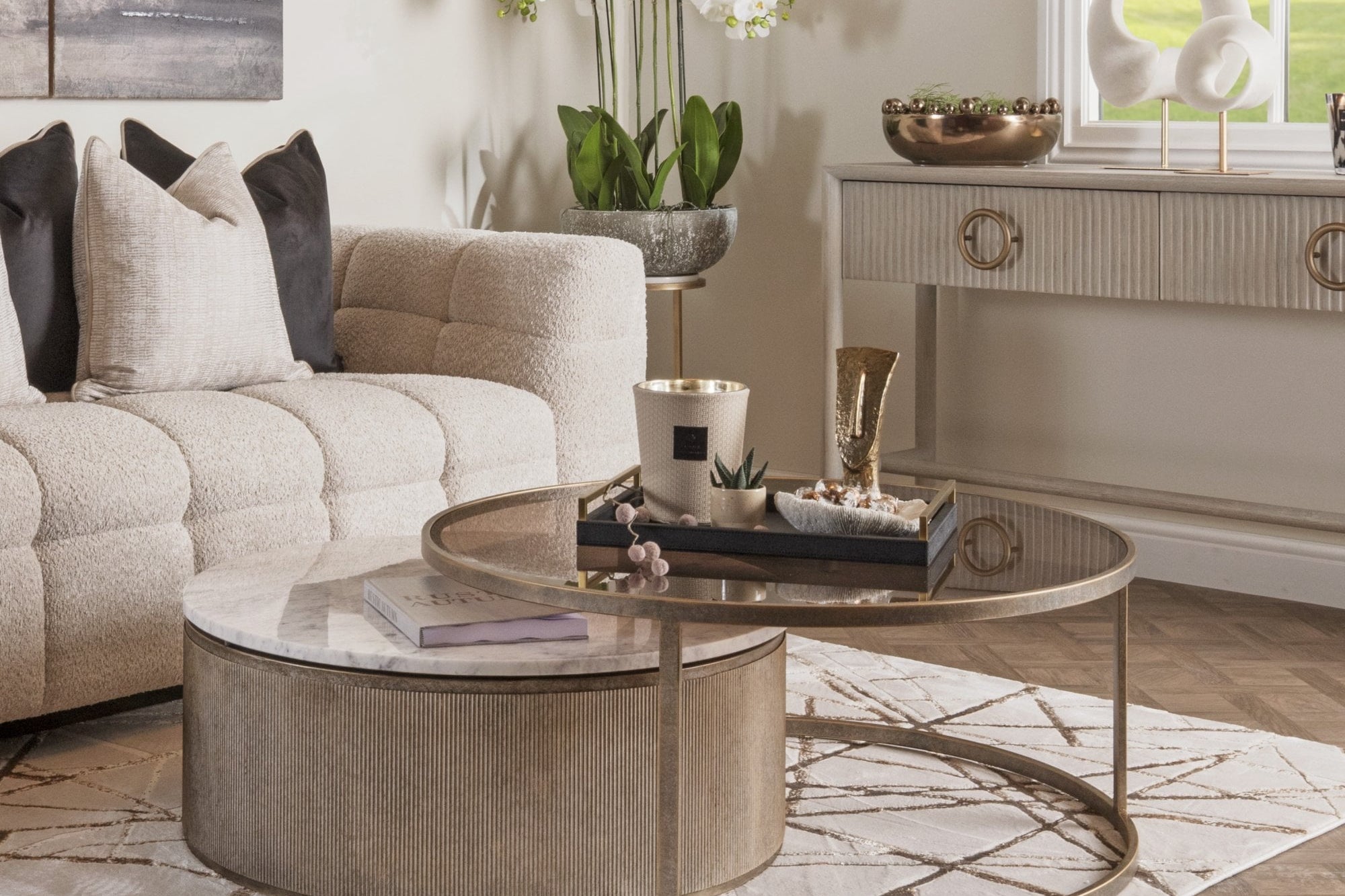 Living room with a beige sofa, round coffee table, and decorative elements.