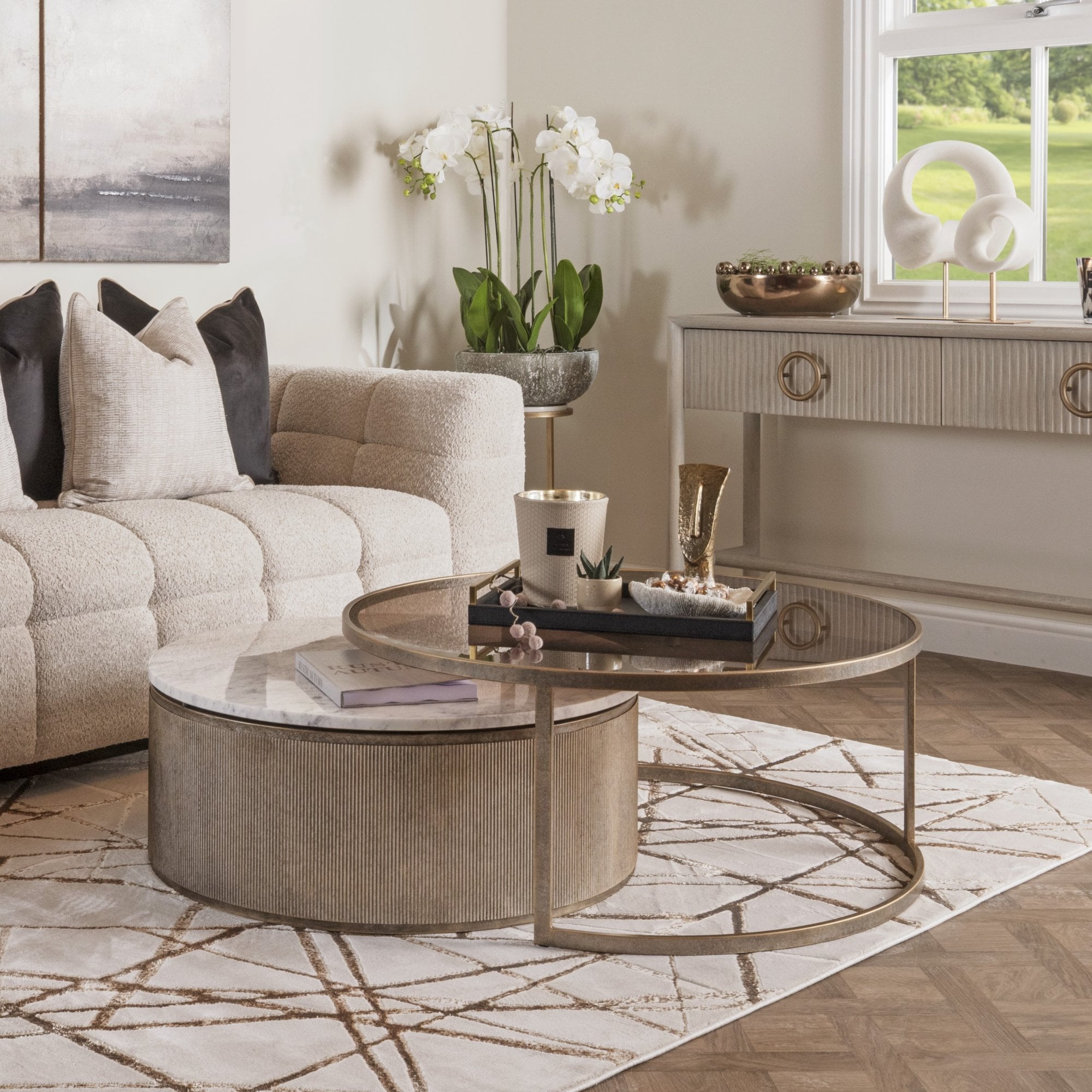 Living room with a beige sofa, round coffee table, and decorative elements.